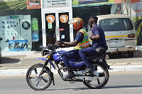 Police officers on motor-bike flout social distance directive. Photo Vincent Dzatse