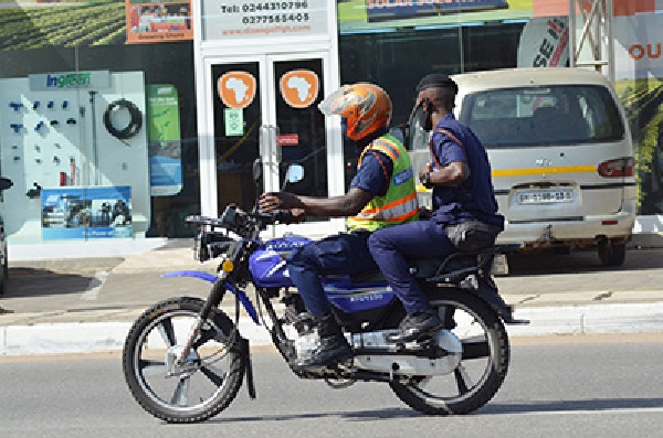 Police officers on motor-bike flout social distance directive. Photo Vincent Dzatse