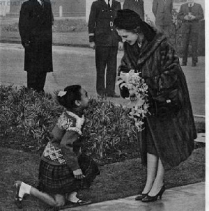 Pearl Acquaye is seen bending the knee after she presents the bouquet to the monarch