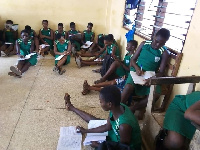 The students, who number over 40, sit on the bare floor for lessons