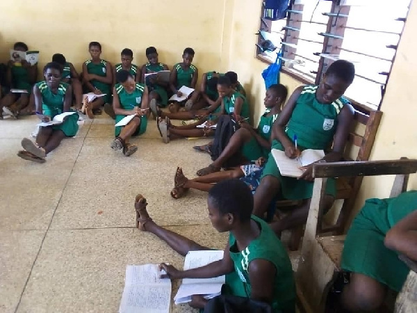 The students, who number over 40, sit on the bare floor for lessons