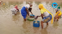 Women in the community fetching water from the dam for domestic use