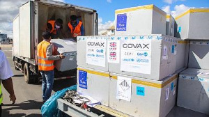 Workers load boxes of Oxford/AstraZeneca Covid-19 vaccines, part of the the Covax programme