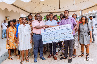 Francis Asenso-Boakye presenting one of the scholarships to a beneficiary