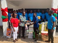 Head coach of Mountaineers FC  presenting the items to Reverend Kwarteng