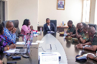 Dr Bernard Okoe Boye (in suit) at the head of the table chairing a meeting