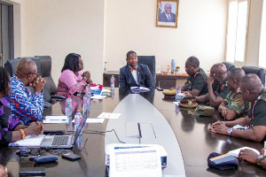 Dr Bernard Okoe Boye (in suit) at the head of the table chairing a meeting