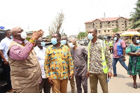 Henry Quartey(L) pointing at the illegal structures under the high tension ready for demolition