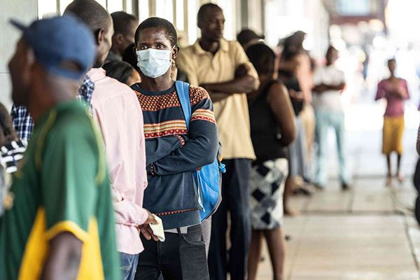 People queue at money transfer service in Bulawayo, Zimbabwe, ZINYANGE AUNTONY | AFP