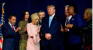 President Donald Trump stands in a prayer circle with faith leaders