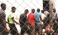 Suspected machete gang members being led into a holding cell at Mazowe Police Camp