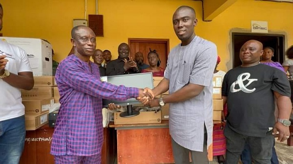 The MP (right) hands over the computers to the headmaster of the school