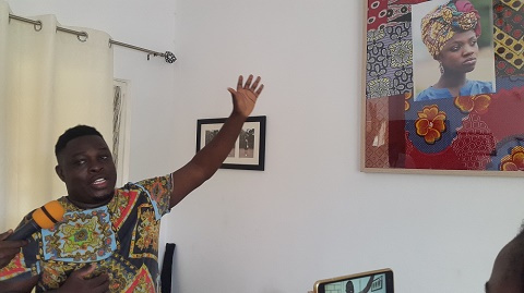 Henry Obimpeh explaining the significane of one of his photgraphs during the tour.