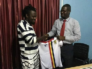 Malik Akowuah with an official of Hearts of Oak during the signing of the contract