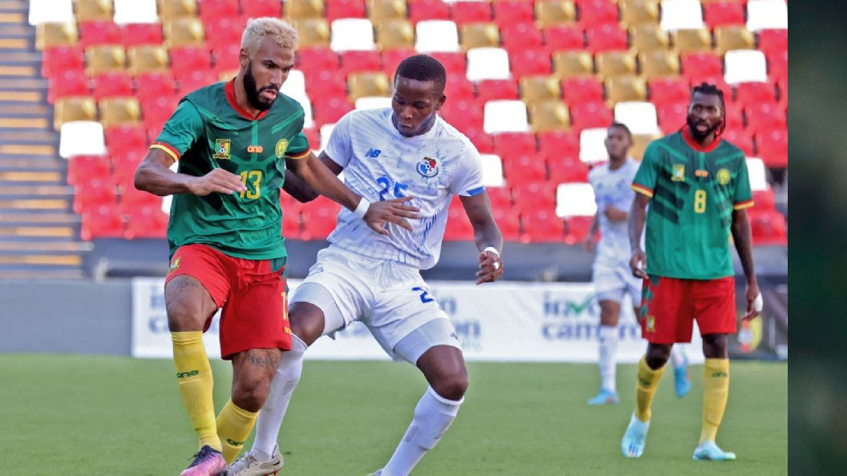 A Cameroonian player fends off an opponent