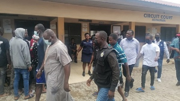 Six accused in handcuffs leaving the court room