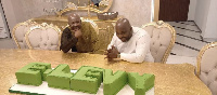 Senyo Hosi and New Juabeng South MP Michael Okyere Baafi in awe of the E-levy cake