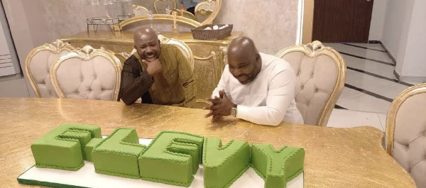 Senyo Hosi and New Juabeng South MP Michael Okyere Baafi in awe of the E-levy cake