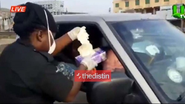 A policewoman giving hand gloves to a driver