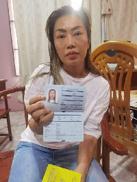 Aisha Huang displays her passport after her rearrest