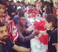 Ghana defender Samuel Inkoom and team mates with some kids