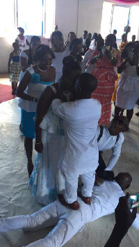 The groom standing on his best man to kiss his bride