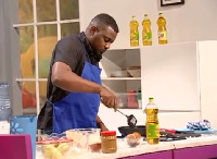 Actor John Dumelo cooking on 'Dining with Cooks and Braggarts' hosted by Yvonne Okoro