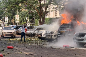 A man extinguishes fire on cars that burnt following the explosion on November 16, 2021