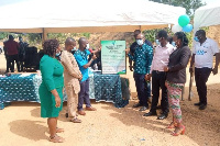 Central Regional NHIA boss (third right) presents citiation to some staff