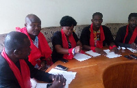 Patrick Cyril Lartey addressing the media and flanked by colleagues