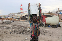 A child carries water from the shore of Jamestown in Accra