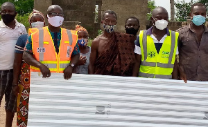 Representatives of the assembly presenting the roofing sheets to affected residents