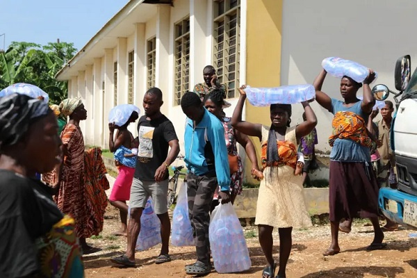 People carrying bags of water