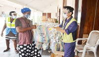 Mr Ilwon Seo (right) presenting the items to one of the kayayei