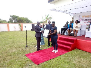 Deputy Attorney General, Godfred Dame presenting the citation to Mercy Tagoe