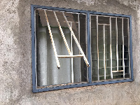 The cut window of one of the burgled homes, through which the robbers entered