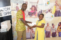 Mr. Bernard Denkyi, Head of Operations at West Hills Mall  presents a shopping voucher to a pupil