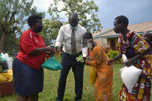 The girl and her mother receive an assortment of items from Genevieve Bamwidhukire.