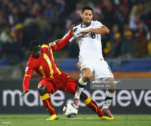 Jonathan Mensah of Ghana is tackled by Clint Dempsey of USA