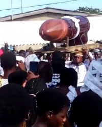 Pallbearers carrying the casket at the funeral grounds