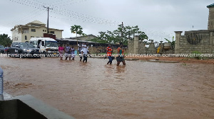 Residents walking through the flood to work (File photo)