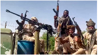 Paramilitary Rapid Support Forces fighters ride in the back of a technical vehicle