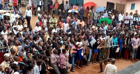 An image of military personnel beating persons who massed up to register