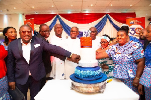 The NPP delegation from Ghana join in cutting the cake to mark the anniversary