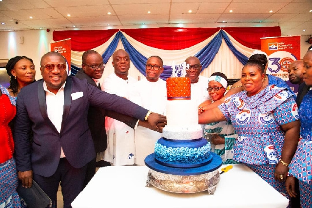 The NPP delegation from Ghana join in cutting the cake to mark the anniversary