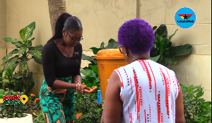 Mrs. Veronica Bekoe supervising hand washing using the Veronica Bucket