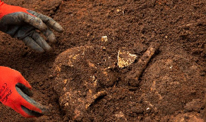 A Burundian worker from the Truth and Reconciliation Commission extracts the skull of an unidentifie