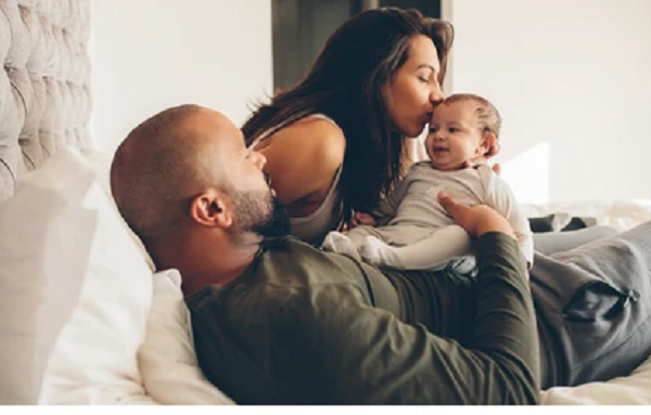 A photo of a couple with their baby