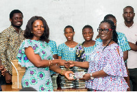 Lydia Seyram Alhassan making the presentation to one of the school heads