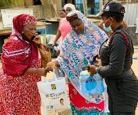 Ghana Police Service person supporting passengers with water